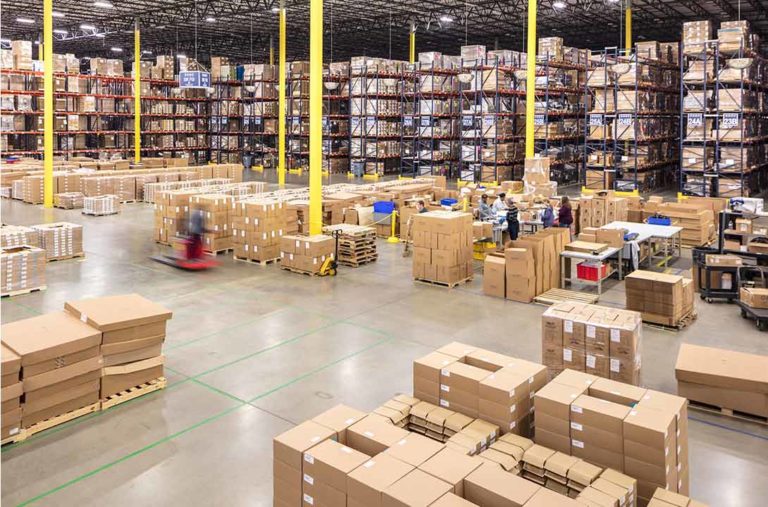 supply warehouse with group of employees organizing boxes