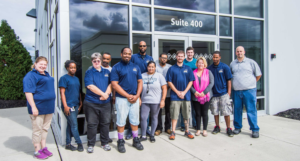 smiling ctdi team standing in front of office building